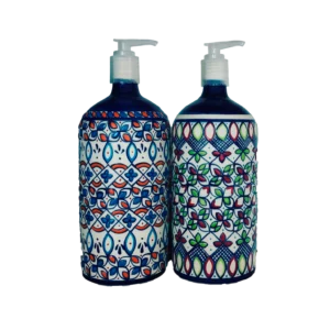 Dos dispensadores de jabón de cerámica artesanal con bomba, decorados con patrones geométricos y florales en tonos azul, rojo y verde sobre fondo claro.