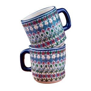 Dos tazas de cerámica artesanal apiladas, decoradas con patrones geométricos y florales en tonos azul, rojo y verde.